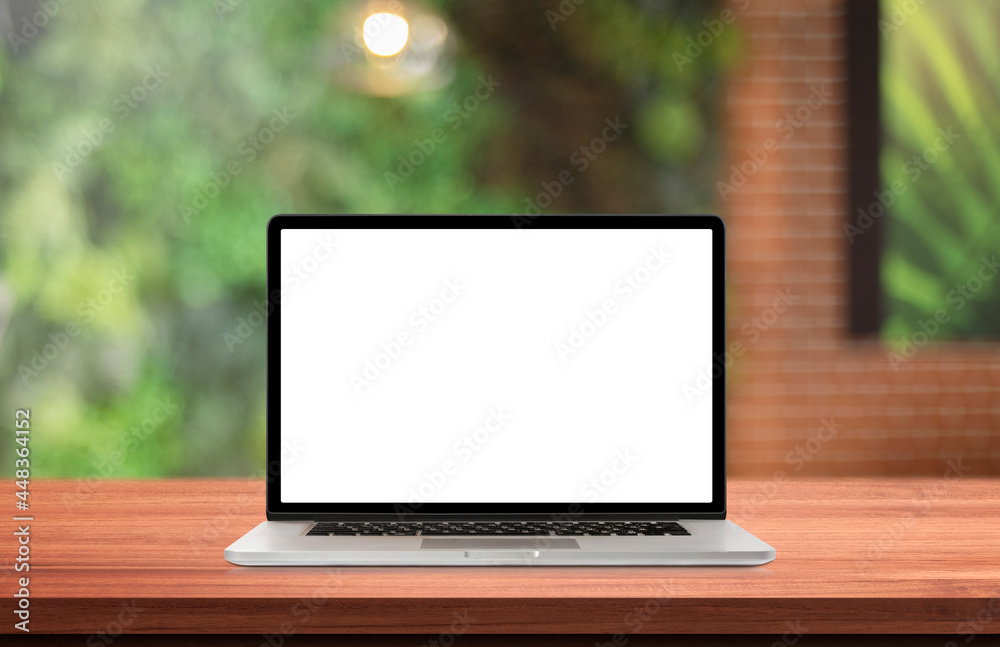 Fototapeta premium Laptop or notebook with blank screen on wood table in blurry background,nature orange bokeh and sunlight in morning.