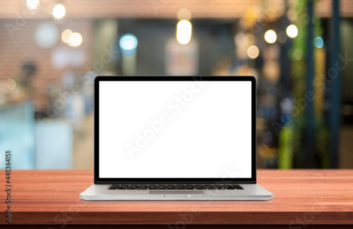 Laptop or notebook with blank screen on wood table in blurry background,nature orange bokeh and sunlight in morning.