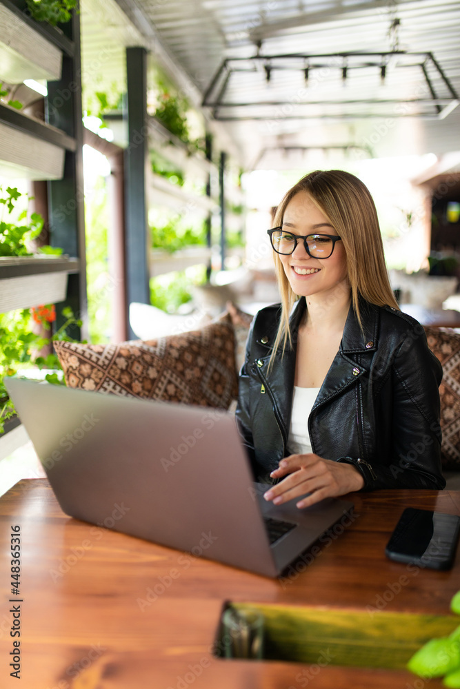 Young woman sitting at cafe with laptop Young woman sitting at cafe with laptop