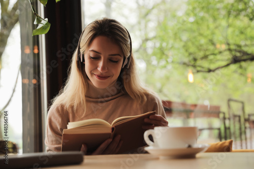 Woman listening to audiobook at table in cafe photo