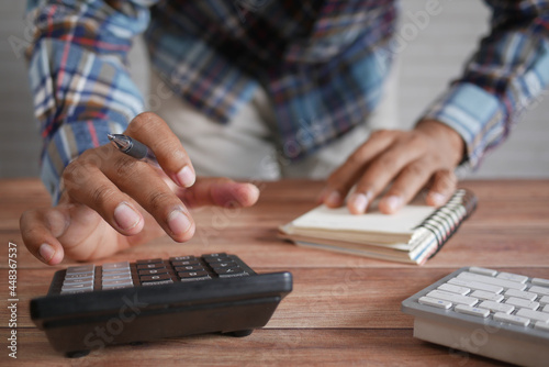 Close up of man hand using calculator