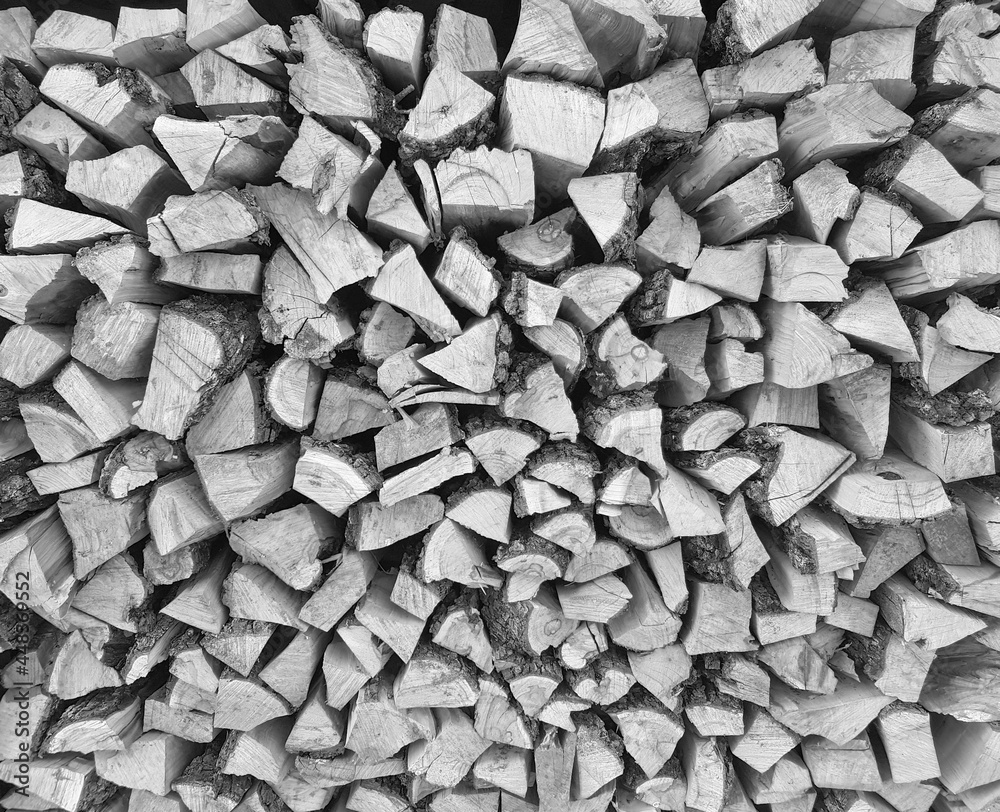 Background of chopped wood lying on top of each other. Pile of chipped wood close-up. Black and white photo Background of chopped wood lying on top of each other. Pile of chipped wood close-up. Black and white photo