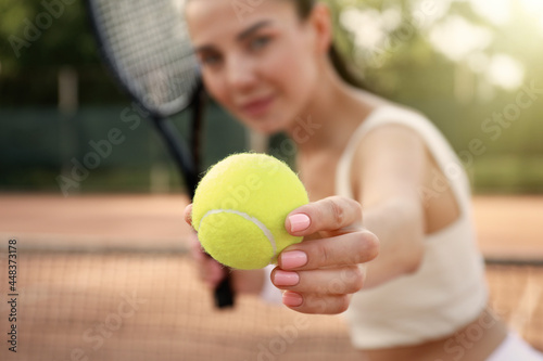 Young woman playing tennis at court, focus on ball © New Africa