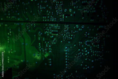 Stylized photo of an electronic microcircuit. Microcircuit, contacts, electronics, motherboard. Black background. Macro photography of electronic devices.
