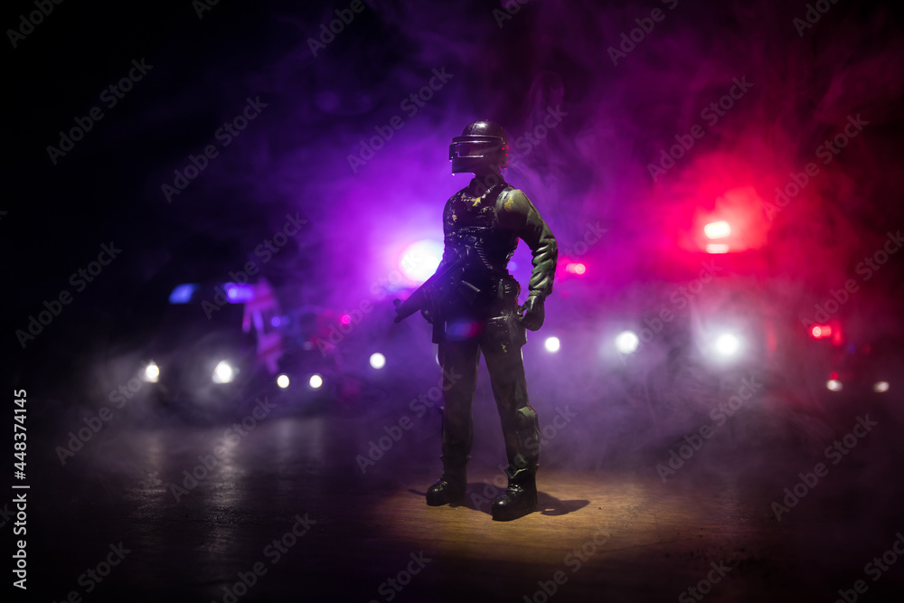 Anti-riot police give signal to be ready. Government power concept. Police in action. Smoke on a dark background with lights. Blue red flashing sirens. Dictatorship power