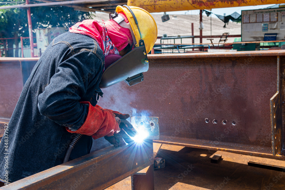Welder is welding a steel plate for steel structure work with process