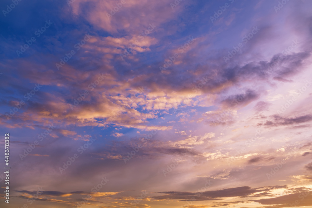 Sunset skyline with fluffy clouds in bright colors. Beautiful natural view of free space. Lovely sundown background.

