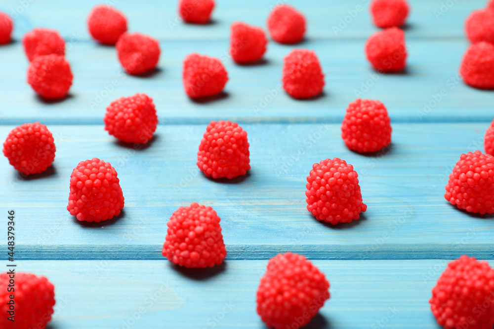 Delicious gummy raspberry candies on light blue wooden table Delicious gummy raspberry candies on light blue wooden table