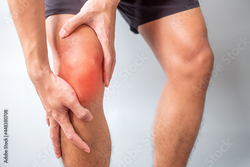 man with muscle pain on grey background. Elderly have knee ache due to Runners Knee or Patellofemoral Pain Syndrome, osteoarthritis, arthritis, rheumatism and Patellar Tendinitis. medical concept photo
