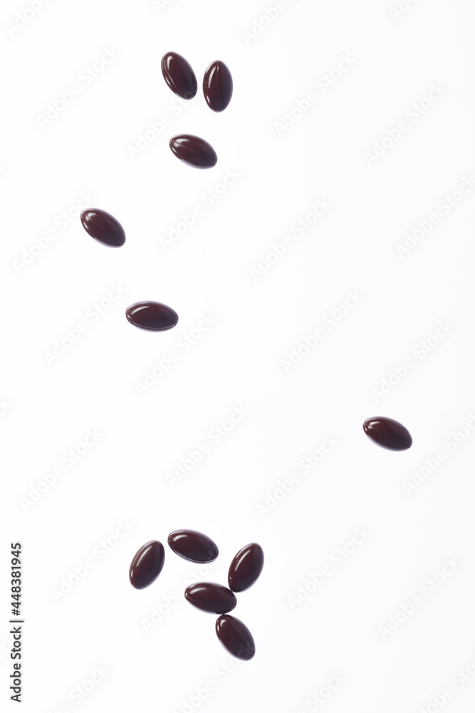 Brown fish oil capsules, vitamins isolated on a white background. Fish oil in gelatin capsules. Fish oil pile. Brown fish oil capsules, vitamins isolated on a white background. Fish oil in gelatin capsules. Fish oil pile.