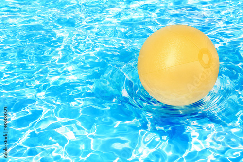 Inflatable beach ball floating in swimming pool © New Africa