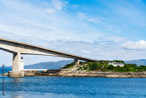 The Scottish Skye Road Bridge as it connects to the small island Eilean Ban in Loch Alsh, Scotland, UK.  Also shown is the Kyleakin Lighthouse photo