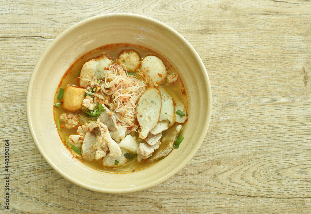 spicy vermicelli noodles topping slice boiled pork and ball in tom yum soup on bowl spicy vermicelli noodles topping slice boiled pork and ball in tom yum soup on bowl
