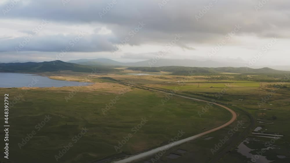 Drone view of a sunset in a valley with a river and mountain ranges Drone view of a sunset in a valley with a river and mountain ranges