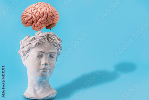 Flying brain from the head of a human statue, creativity and science concept.