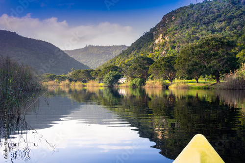 Scenic river canoe trip with tranquil reflections of mountains and trees on river edge near Knysna in South Africa photo