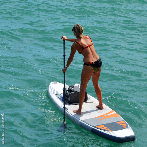 Attractive woman standing on a paddle board