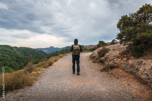unrecognizable man walking on a mountain path on a cloudy day in Catalonia, Spain. Adventure travel.