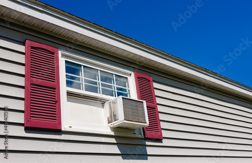 Air conditioner in house window on Summer day.