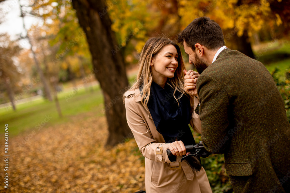 Young couple in the autumn park with electrical bicycle Young couple in the autumn park with electrical bicycle