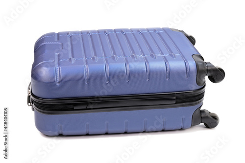 A blue plastic suitcase with a zipper and wheels, lying on its side