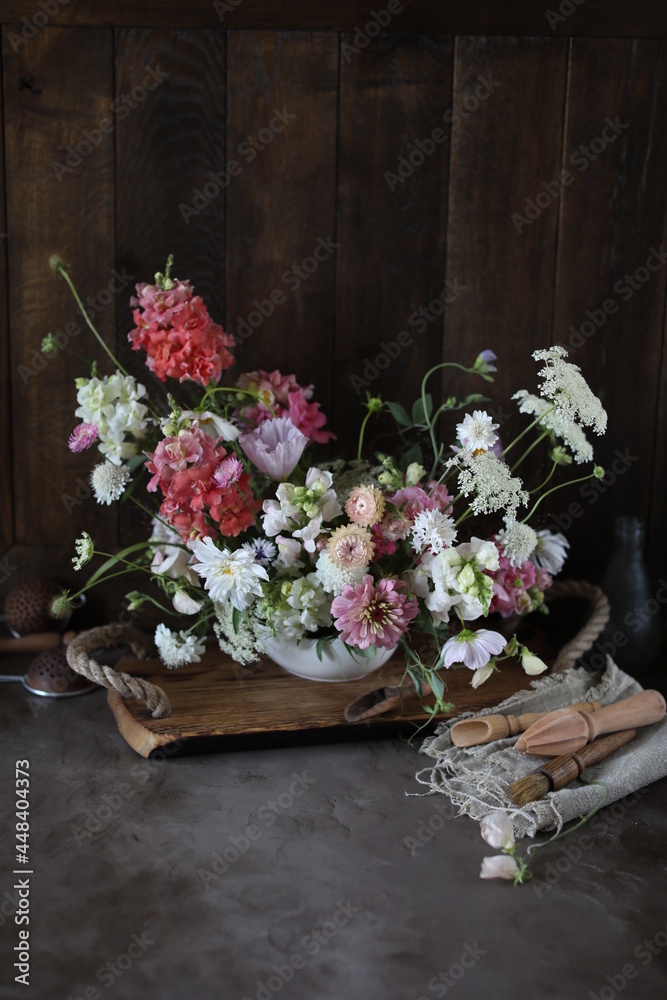 Fototapeta premium Floral arrangement of summer garden flowers in pastel shades on the table. English floristry. Still life.