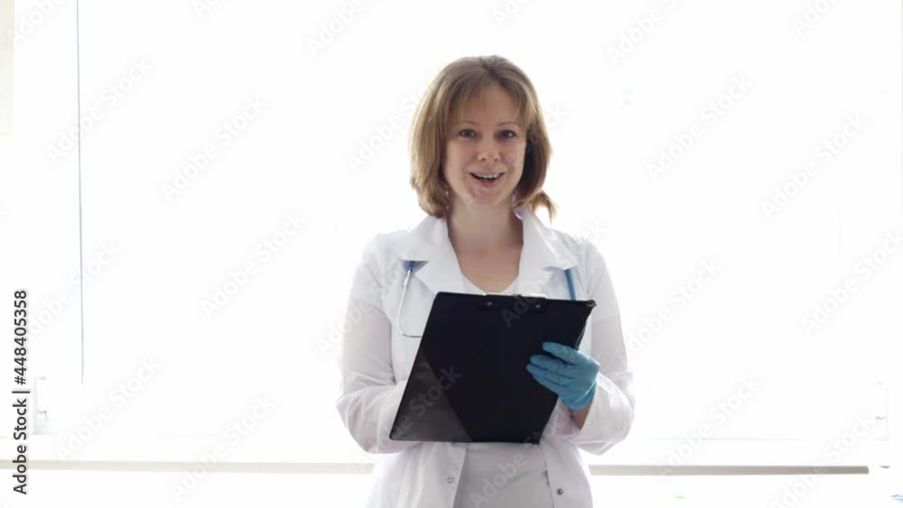 nurse talking to the patient,smiling, writes it down in the medical card nurse talking to the patient,smiling, writes it down in the medical card