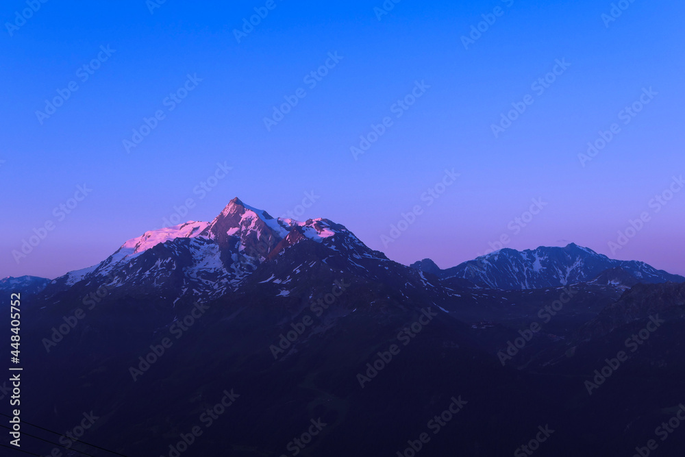 Fototapeta premium Pink sunrise or sunset on mountain. Beautiful landscape with clear sky over the summit of a valley in alps.