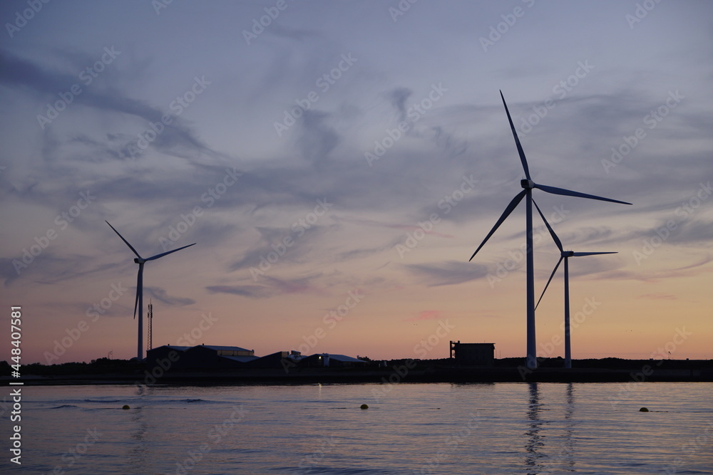Windmills at sea by nightfall