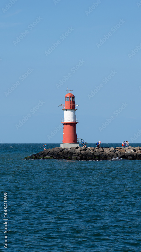 Red and white lighthouse on the Baltic Sea (inland sea) with cloudless sky and bright sunshine Red and white lighthouse on the Baltic Sea (inland sea) with cloudless sky and bright sunshine