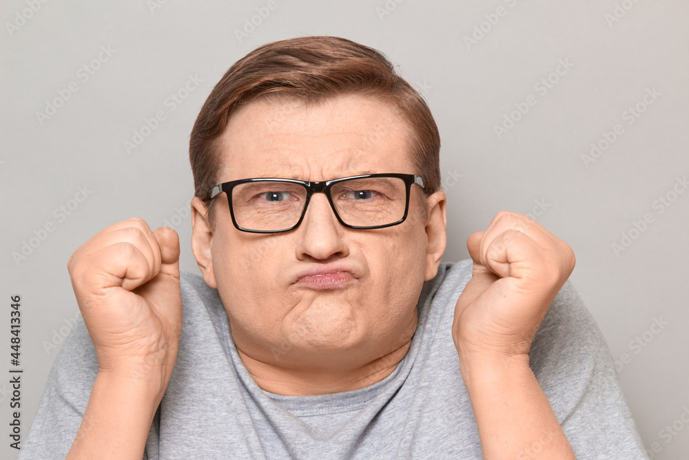 Portrait of funny disgruntled man shaking fists in threatening gesture Portrait of funny disgruntled man shaking fists in threatening gesture