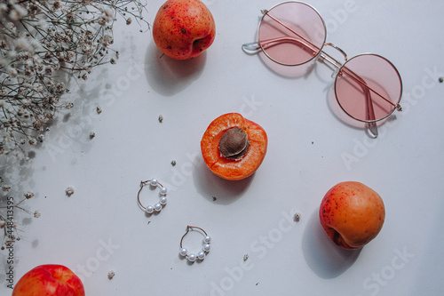 жемчужные серьги,розовые очки, персики абрикосы и цветы на белом фоне
