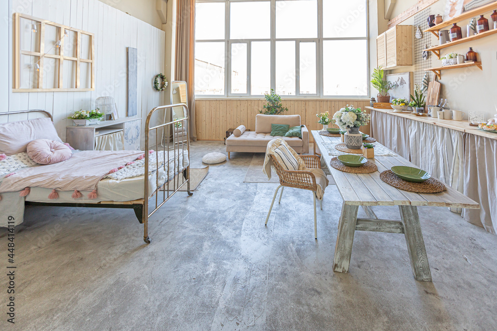 simple cozy home interior of an open plan ordinary room with a kitchen and bedroom area