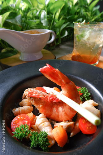 Close up Tom Yum Goong. Thailand classic stew with shrimp, dory fish, squid and Menta mojito drink