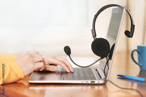 Laptop. Mockup screen and headphones on wooden desk and plain background banner. Distant learning. working from home, online courses or support minimal concept. Helpdesk or call center headset