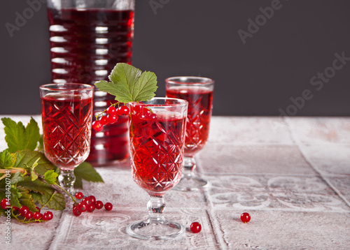 Fotografia glasses of red currant brandy liqueur with ripe berries