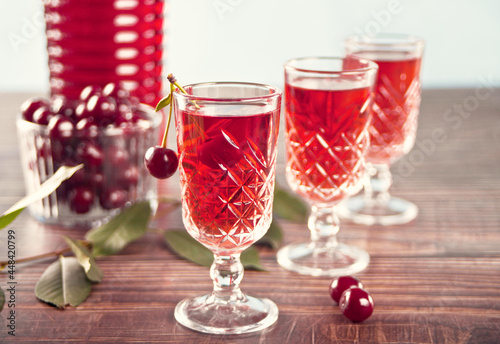 Photos glasses of cherry brandy liqueur with ripe berries