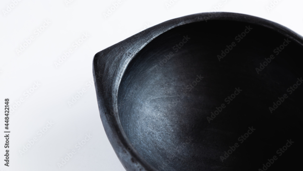 black clay soup plate very typical of the Colombian culture, White background.