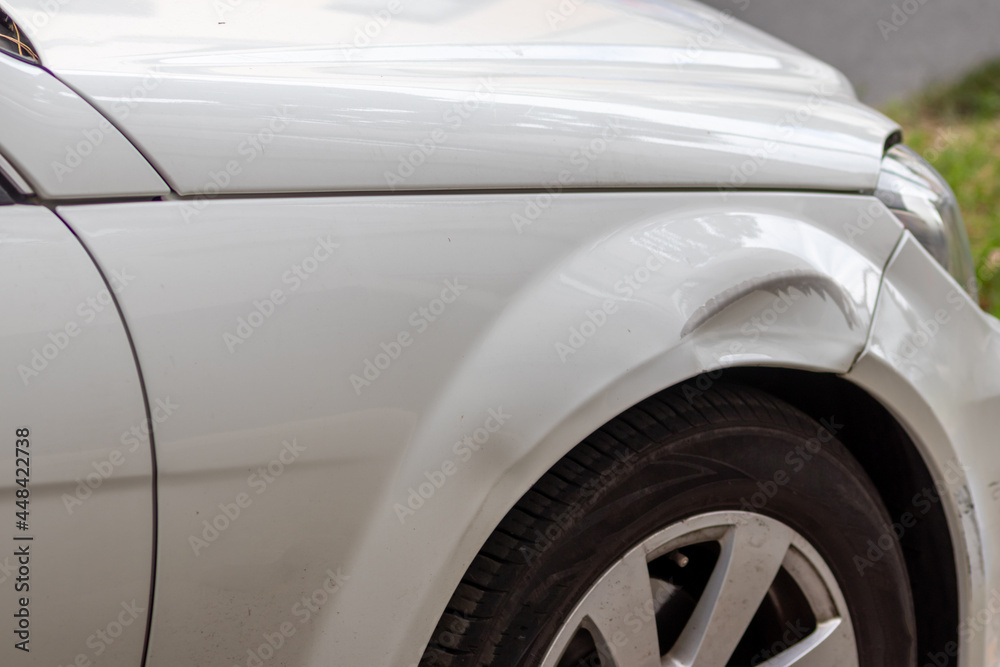 Dented car wing and fender with scratches and bumps after crash and car accident with hit-and-run driving and absconding shows need for car insurance and safety protection and mechanics garage service Dented car wing and fender with scratches and bumps after crash and car accident with hit-and-run driving and absconding shows need for car insurance and safety protection and mechanics garage service