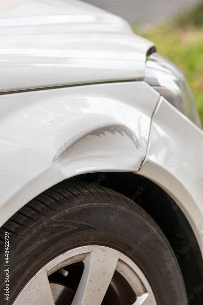 Dented car wing and fender with scratches and bumps after crash and car accident with hit-and-run driving and absconding shows need for car insurance and safety protection and mechanics garage service Dented car wing and fender with scratches and bumps after crash and car accident with hit-and-run driving and absconding shows need for car insurance and safety protection and mechanics garage service