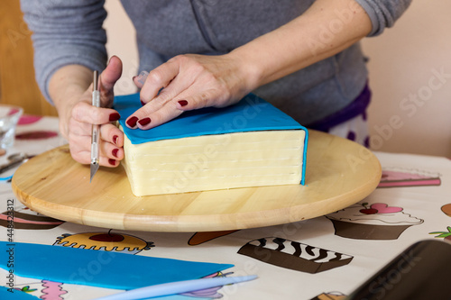 Cuadro en lienzo Woman hands smoothing fondant for cake decoration