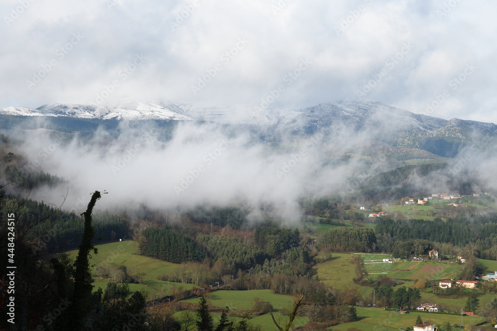 Typical landscape of a valley with mist and meadows in the Basque Country