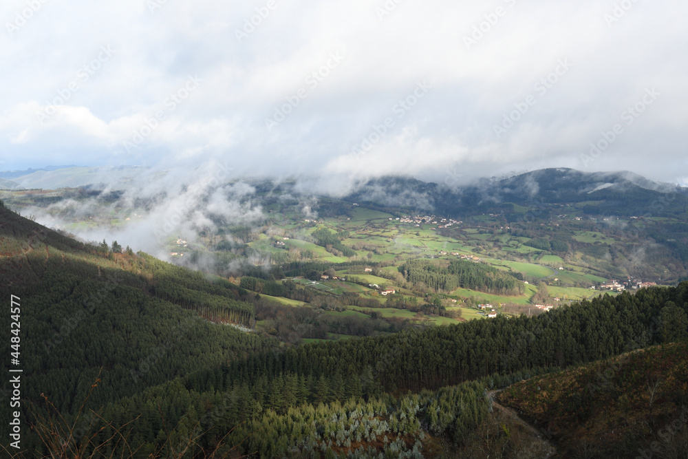 Typical landscape of a valley with mist and meadows in the Basque Country