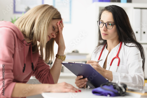 Принти на полотні Young woman under stress from medical diagnosis at clinic appointment