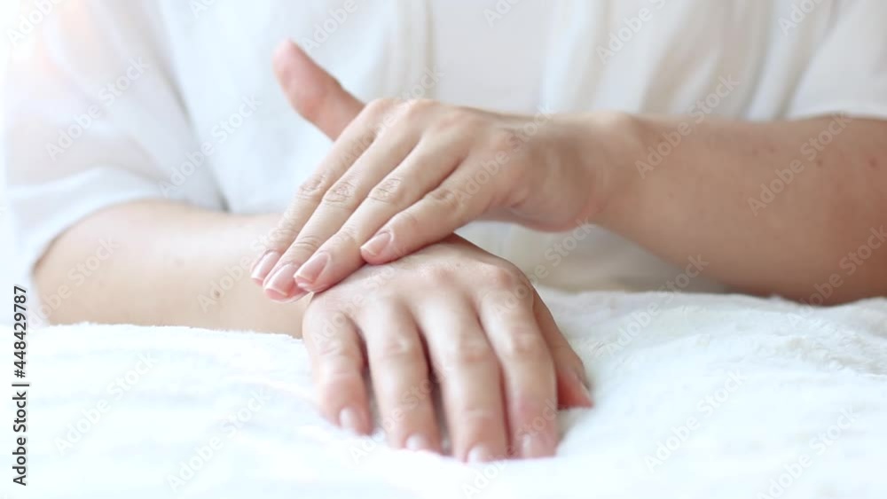 Young white woman rubbing moisturizer on the skin of her right hand. Skin care concept Young white woman rubbing moisturizer on the skin of her right hand. Skin care concept