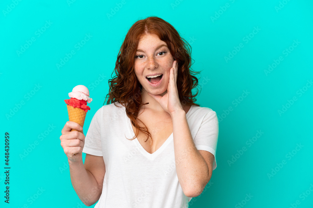 Teenager reddish woman with a cornet ice cream isolated on blue background with surprise and shocked facial expression Teenager reddish woman with a cornet ice cream isolated on blue background with surprise and shocked facial expression