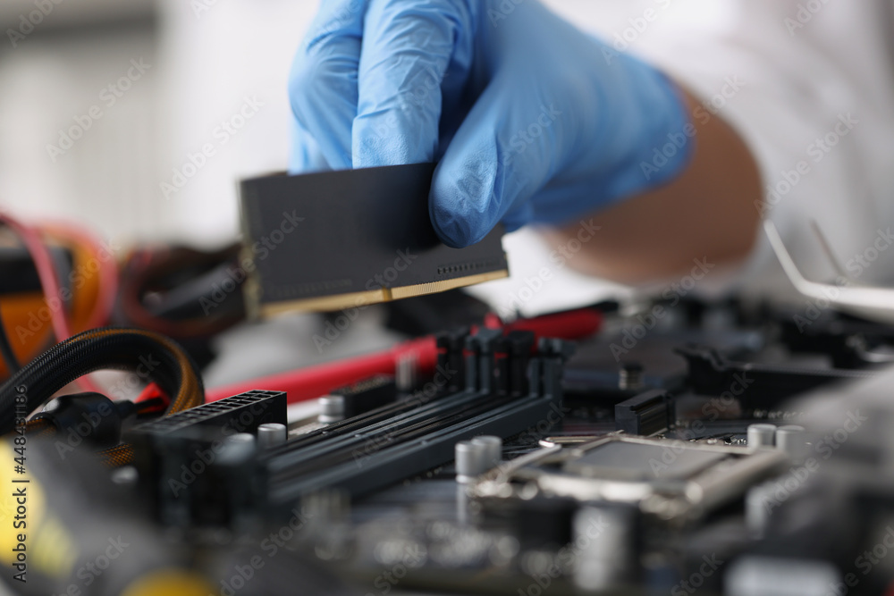 Gloved technician diagnoses broken computer equipment closeup Gloved technician diagnoses broken computer equipment closeup