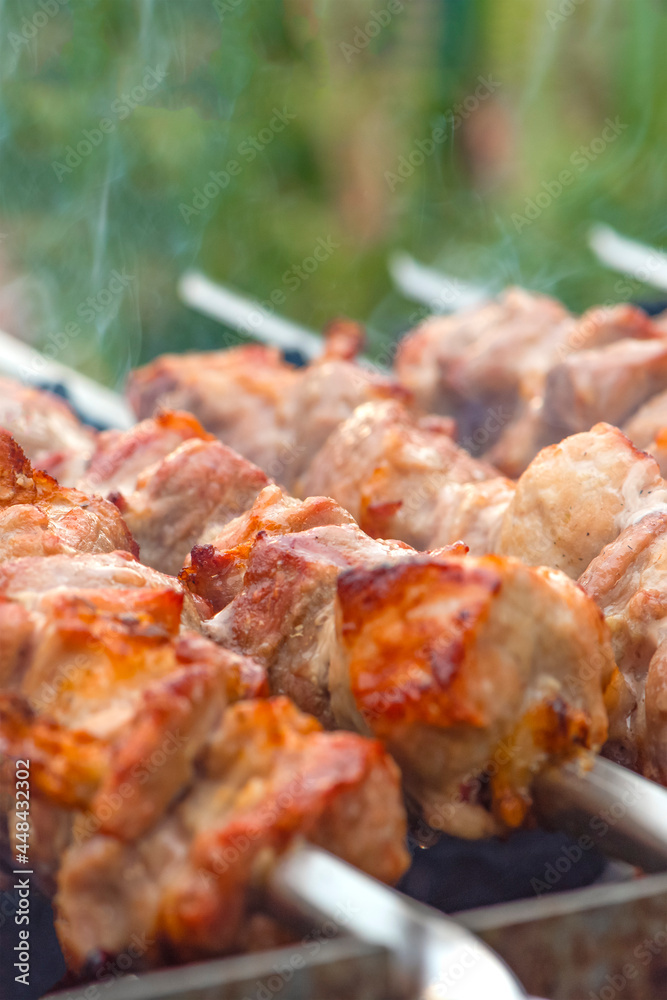 Cooking barbecue, grilled meat barbecue. Cooking pork shashlik on metal skewers. Smoke from embers builds up over the dish. Advertising banner with copy space