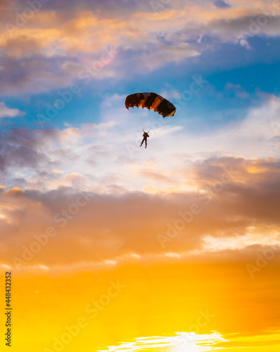 Skydiver On Colorful Parachute In Sunny Sunset Sunrise Sky