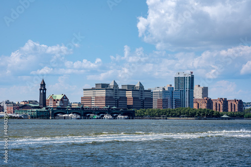 Obraz na plátně Hoboken, NJ - USA - July 30, 2021:  Wide angle horizontal view of the Hoboken waterfront, featuring Hoboken Terminal, ferry docks, the W Hoboken Hotel and Hudson River Waterfront Walkway